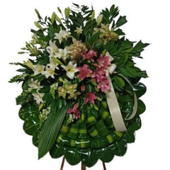 Corona fúnebre con orquídeas, lirios, bocas de dragón y/o estrella de belén